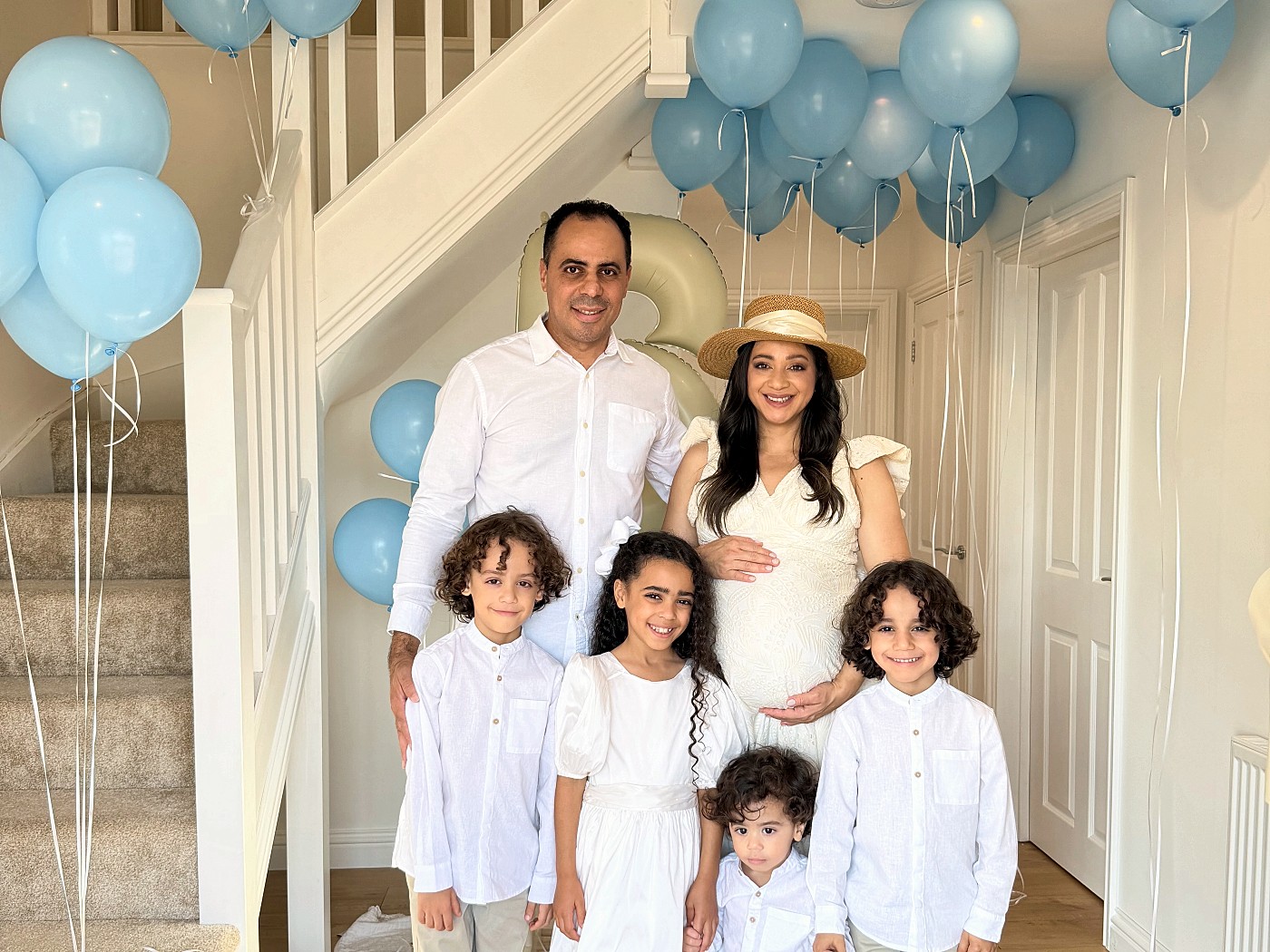 Anna, Jorge e os filhos, todos de branco, em casa